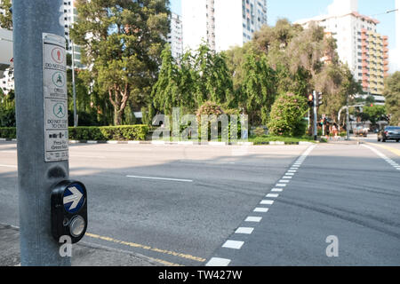 Ein mit einem fußgängerüberweg Taste drücken Punkt in Singapur mit einem leeren Straße vor. Stockfoto