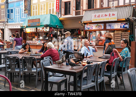 Tauben setzen sich auf die Tische bei der Hawker Food Court in China Town Food Street stall Singapur Stockfoto