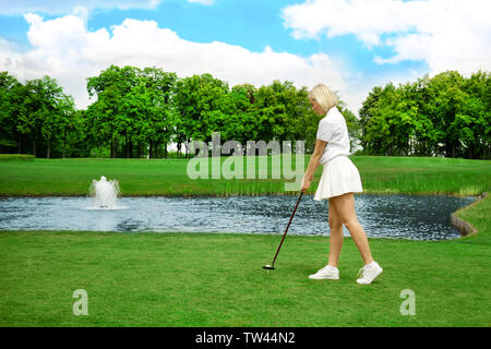 Schöne junge Frau spielen Golf auf Kurs im Sommer Tag