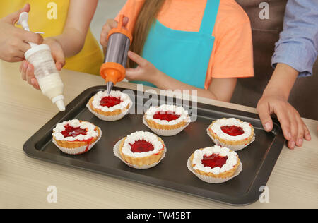 Gruppe von Kindern und Lehrer Vorbereitung Dessert während Kochkurse Stockfoto