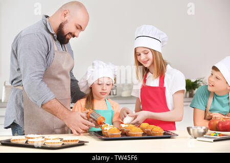 Gruppe von Kindern und Lehrer Vorbereitung Dessert während Kochkurse Stockfoto