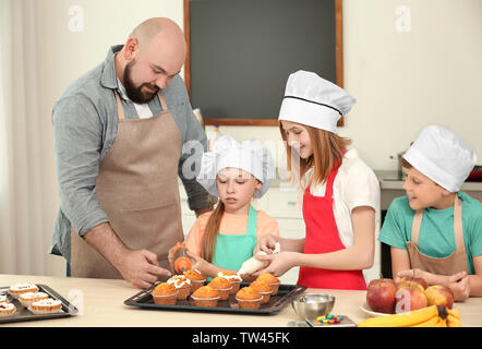 Gruppe von Kindern und Lehrer Vorbereitung Dessert während Kochkurse Stockfoto