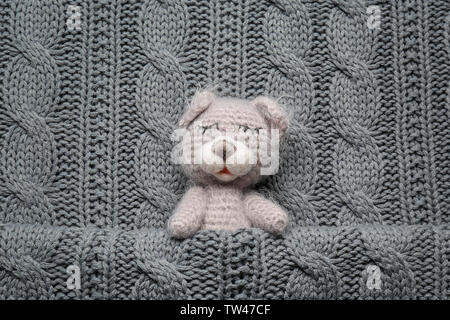 Cute handgemachte Spielzeug Bär auf gestrickte Hintergrund Stockfoto