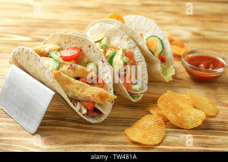 Mit leckeren Fisch Tacos auf hölzernen Hintergrund abheben Stockfoto