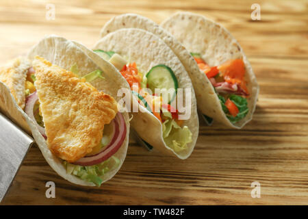 Mit leckeren Fisch Tacos auf hölzernen Hintergrund abheben Stockfoto