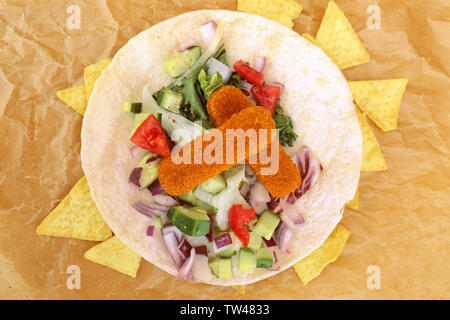 Lecker Fisch taco mit Chips auf Pergament Stockfoto