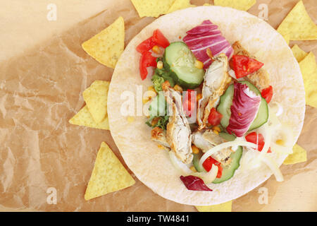 Lecker Fisch taco mit Chips auf Pergament Stockfoto