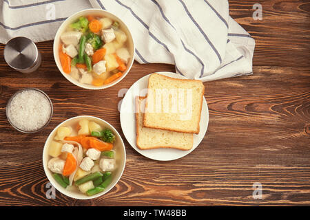 Zusammensetzung mit köstlichen Türkei Suppe in zwei Schüsseln auf hölzernen Tisch Stockfoto