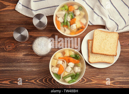 Zusammensetzung mit köstlichen Türkei Suppe in zwei Schüsseln auf hölzernen Tisch Stockfoto