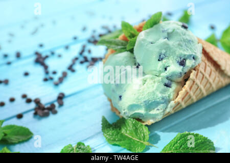 Köstliche mint Chocolate Chip Eis in der Waffel Kegel auf Holz- Hintergrund, Nahaufnahme Stockfoto