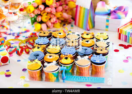 Cupcakes für Kinder Geburtstag feiern. Dschungel Tiere Thema Kinder Party. Zimmer für Junge oder Mädchen Junge Geburtstag eingerichtet. Tabelle Einstellung mit Geschenken, Stockfoto