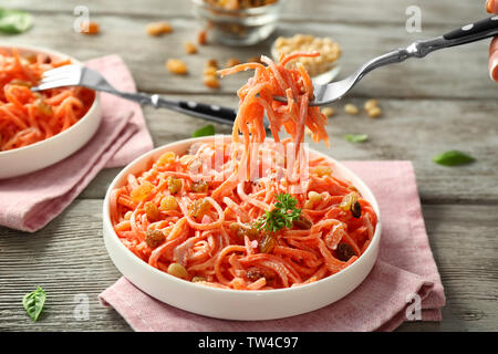 Gabel und Teller mit leckeren Karotte Rosinen Salat auf hölzernen Tisch Stockfoto