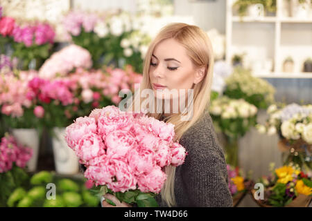 Junge Frau mit schönen Päonien in Flower Shop Stockfoto