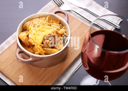 Mit leckeren gebackenen Kartoffeln und Käse auf dunklen Tabelle Kasserolle Stockfoto
