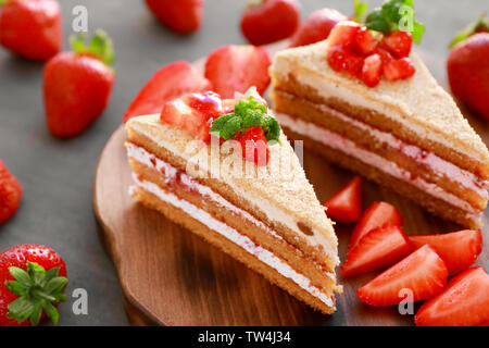 Zwei Stück hausgemachten Kuchen mit Erdbeeren auf Holzbrett Stockfoto