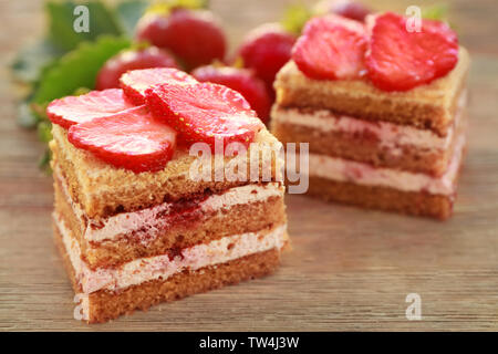 Zwei Stück hausgemachten Kuchen mit Erdbeeren auf hölzernen Tisch Stockfoto