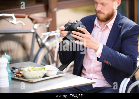 Junge Blogger arbeiten mit Kamera am Tisch, im Freien Stockfoto