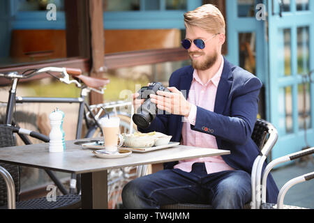 Junge Blogger arbeiten mit Kamera am Tisch, im Freien Stockfoto