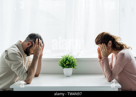 Umgekippt, Mann und Frau zu Hause sitzen nach Streit Stockfoto