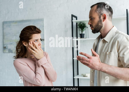 Angst Frau berühren und wütenden Mann zu Hause suchen Stockfoto