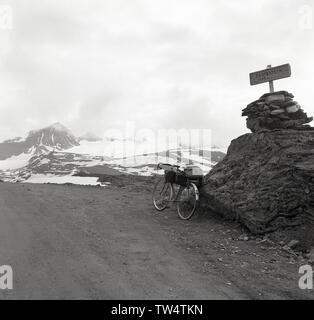 1950, historische, Radwandern in Italien, einem tourenrad auf einer Schotterstraße Ggeen einem großen Kalkfelsen mit einem Schild auf der Oberseite sagt 'Fantestein', 1435 moh, hoch oben im Schnee Dolomiten, ein Gebirge im Nordosten des Landes abgedeckt geparkt. Stockfoto