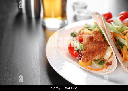 Lecker Fisch Tacos auf weißen Teller am Tisch Stockfoto