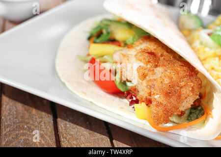 Lecker Fisch taco serviert auf weiße Platte auf hölzernen Tisch Stockfoto