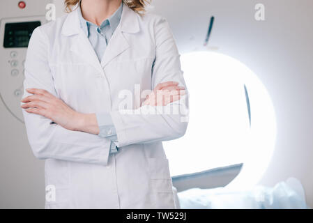 Teilansicht der Radiologe stand mit verschränkten Armen in der Nähe von Computertomograph Stockfoto