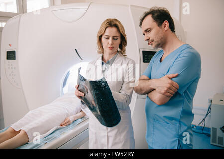 Nachdenkliche ärzte suchen an x-ray Diagnose während des Patienten eine Diagnose für CT-Scanner Stockfoto