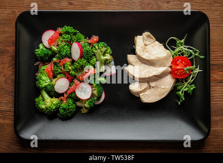 Mit Brokkoli Salat und Hühnchen auf der Tischplatte Stockfoto