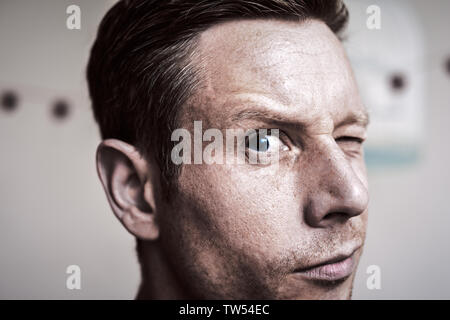 Ernst, aber neugieriger Mann direkt an der Kamera auf der Suche Stockfoto