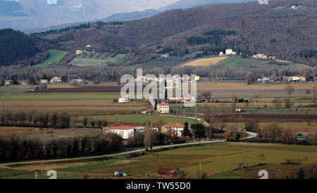 Toskana, Italien, Straße im Valtiberina Land mit umliegenden Bauernhäusern und landwirtschaftlichen Feldern. Eine Landstraße in Evidenz Stockfoto