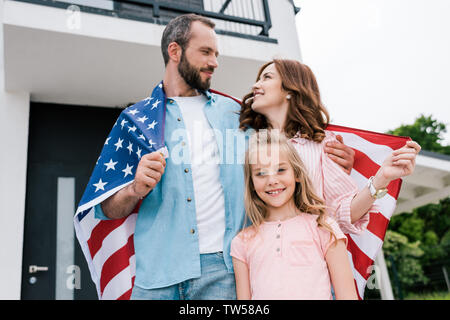 Low Angle View von Happy kid in der Nähe von fröhlichen Eltern mit amerikanischer Flagge Stockfoto