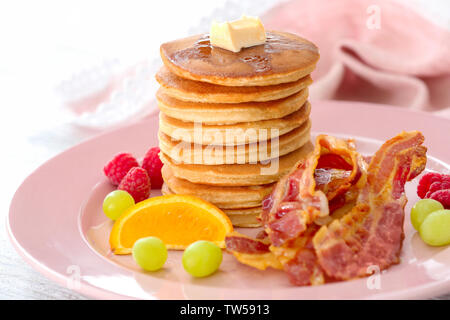 Mit leckeren Pfannkuchen, Speck und Früchte auf der Tischplatte Stockfoto