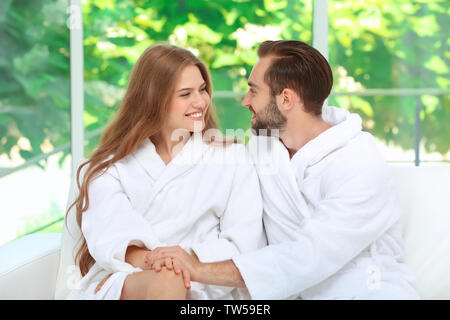 Junge liebende Paar in Bademäntel zu Hause Stockfoto