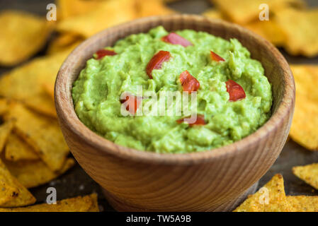Guacamole in Holzschale mit Tortilla-Chips Stockfoto