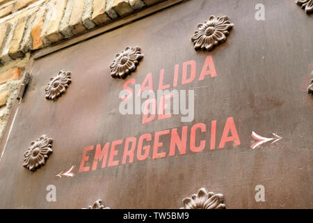 Notausgang Schild in spanischer Hand auf der Außenseite der Metalltür in Granada, Spanien gemalt. Stockfoto
