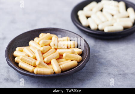 Coenzym Q10 und Alpha Liponsäure kapseln. Immunsystem unterstützen. Konzept für eine gesunde Nahrungsergänzung. Helle Stein Hintergrund. Close Up. Stockfoto