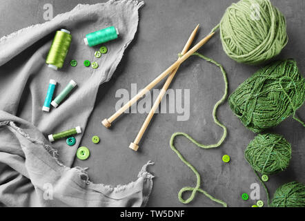 Zusammensetzung mit grünen Nähgarne und Strickgarn auf Tisch Stockfoto