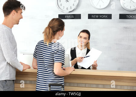 Junges Paar an der Rezeption im Hotel Stockfoto