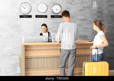 Junges Paar an der Rezeption im Hotel Stockfoto