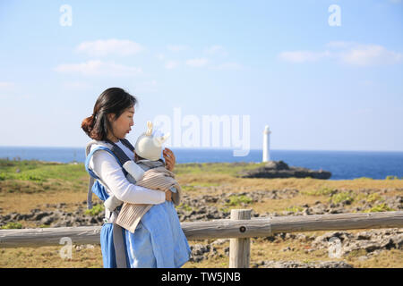 Asiatische Mutter und er Baby in der Familie Reise in Zanpa Seaside Park am Kap Zanpa in Okinawa, Japan Stockfoto