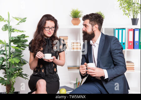 Büro Gerüchte. Büro Kaffee. Paar Kollegen Kaffeepause entspannen. Teilen Kaffee mit Kollegen. Flirten Kollegen. Mann und attraktive Frau mit Bart. Mann und Frau Gespräch Kaffee Zeit. Stockfoto