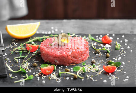 Lecker Steak Tartar mit Eigelb auf schiefer Platte Stockfoto