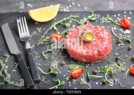 Lecker Steak Tartar mit Eigelb auf schiefer Platte Stockfoto