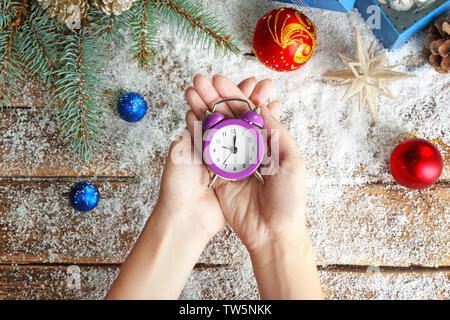 Frau mit retro Wecker über Tabelle. Christmas countdown Konzept Stockfoto