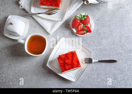 Mit Erdbeer bretzel Salat und Tasse Tee auf der Tischplatte Stockfoto