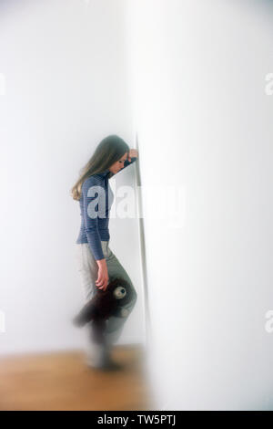 Junger Teenager halten einen Teddybären in der Ecke der Zimmer sehr deprimiert Stockfoto
