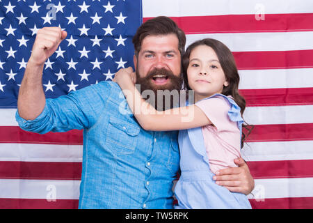 Ehrenkompanie der grosse Banner. Patriotische Familie feiern Flag Tag mit Banner Dekor. Vater und Tochter auf die amerikanische Fahne Hintergrund. Mann und einem kleinen Kind mit nationalen us banner Bärtigen. Stockfoto