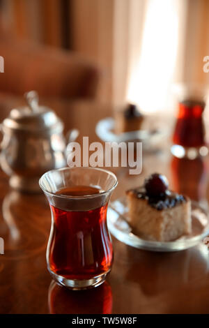 Türkischer Tee im traditionellen Glas mit Dessert auf den Tisch Stockfoto